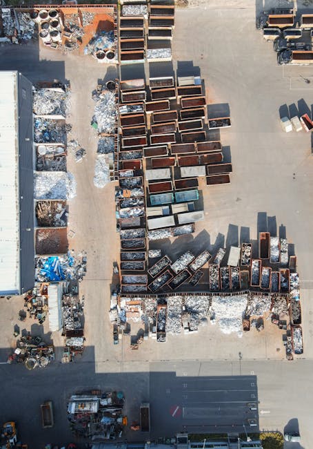 In the image, a large pile of mixed rubbish is situated on a paved driveway or outdoor surface, with various materials visible. Prominent in the foreground are several large cardboard boxes, some flat
