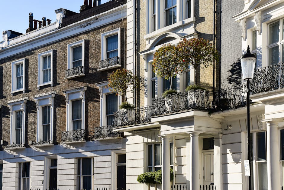 A multi-storey brick building with large rectangular windows featuring dark blue and white decorative trim, situated above a red brick structure with arched windows and a sign reading 'COVENT GARDEN S